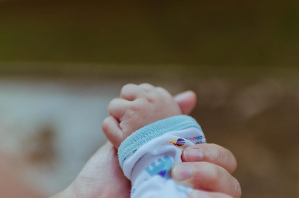 Støtte fra Start. Billede af babys hånd.